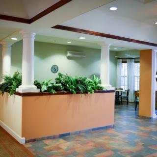 A well-lit interior lobby area with plants and columns.