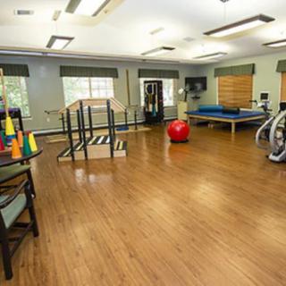 A spacious indoor gym with exercise and rehabilitation equipment.