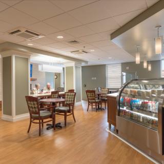 A modern cafe interior with dining tables and a display counter.