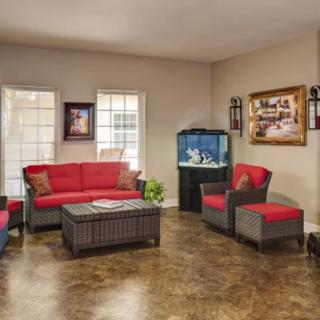 A cozy living room with red furniture, an aquarium, and decorative wall art.