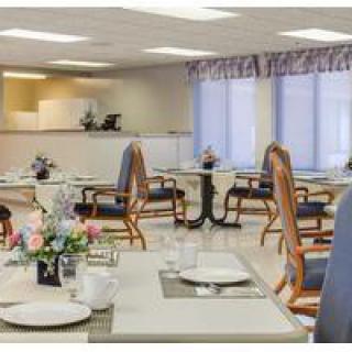 A well-arranged dining area with neatly set tables, decorated with flowers.