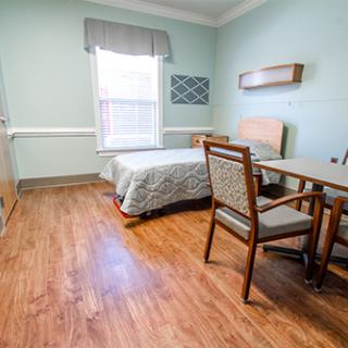 A well-lit and spacious hospital room equipped with essential furniture.