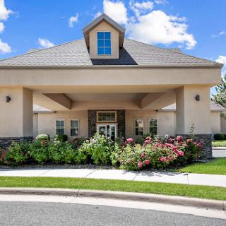 A charming residential building featuring a beautiful garden in front.