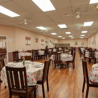 An empty restaurant dining area with neatly arranged tables and chairs.
