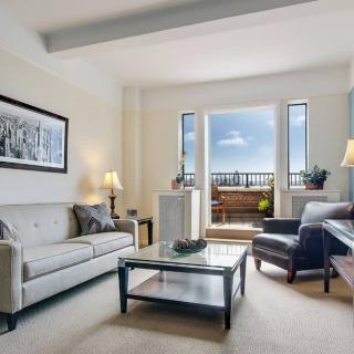 A cozy living room with comfortable seating, elegant decor, and a scenic balcony view.