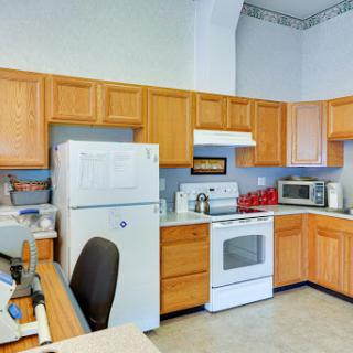 A modern kitchen featuring wooden cabinets and essential appliances.