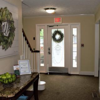 A well-decorated entrance with a wreath on the door and a staircase leading to the upper floor.