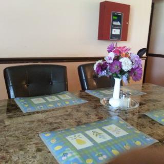 A dining table set with flower decorations and table mats in an indoor setting.