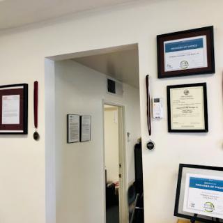 An office space featuring framed certificates and awards on the walls.