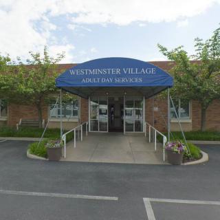 Entrance to Westminster Village with a blue awning and accessible ramp.