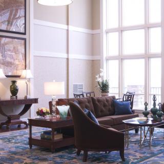 A spacious living room with elegant decor and large windows letting in natural light.