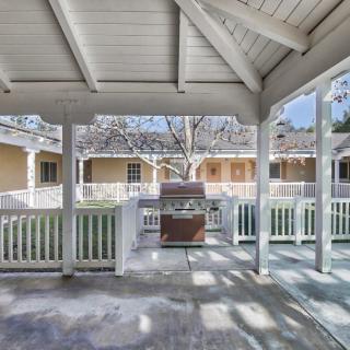 A covered patio area with a barbecue grill and surrounding porch.