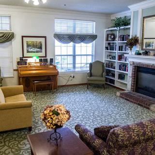 A cozy living room with a fireplace, bookshelf, and comfortable seating.