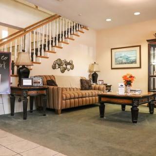 A cozy living room with a sofa, coffee table, and decorative elements near a staircase.