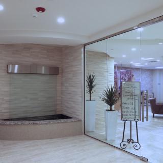A modern and elegant waiting area with a glass partition and decorative plants.