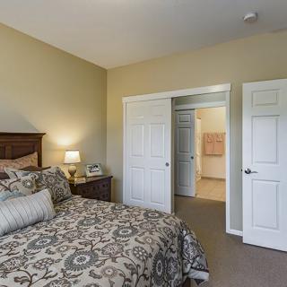 A cozy bedroom with decorative bedding and a closet.