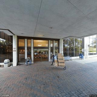 People transporting items at the entrance of a modern building.