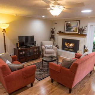 A cozy living room with sofas, a fireplace, and a television.