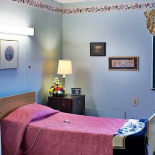 A cozy hospital room with a single bed and soft lighting.