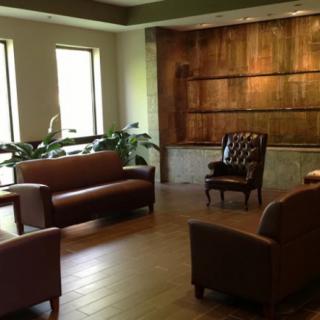 A well-furnished waiting room with comfortable seating and wooden accents.