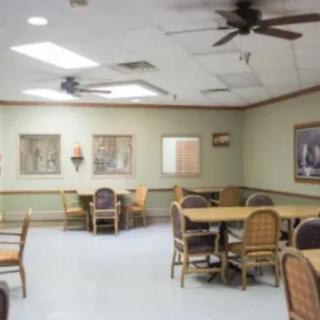 An interior view of a dining room with tables, chairs, and ceiling fans.