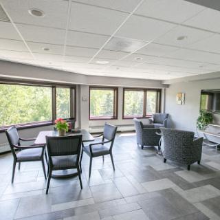 A bright and modern lounge area featuring comfortable seating and large windows, perfect for relaxation.