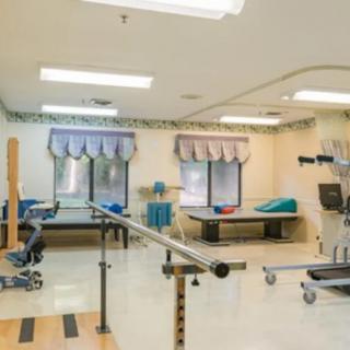 A well-equipped rehabilitation and physical therapy room with various exercise equipment.