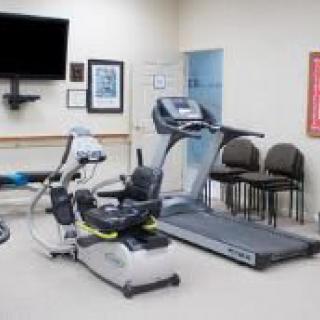 A small indoor gym with various exercise equipment, including a treadmill.