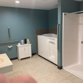 An accessible bathroom featuring a walk-in bathtub and shower area.