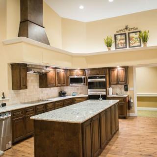 A modern kitchen interior with wooden cabinets and a large island.
