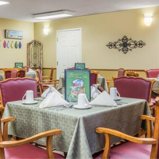 An elegantly set dining room table with folded napkins and comfortable seating.
