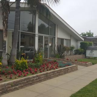 A modern building with large glass windows and landscaped garden area.
