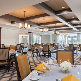 An elegant dining room set with tables, chairs, and chandeliers.