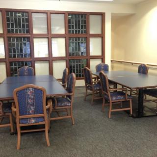 A quiet study area in a library with several tables and chairs.