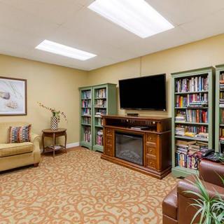 A cozy reading room with bookshelves, a TV, and comfortable seating.