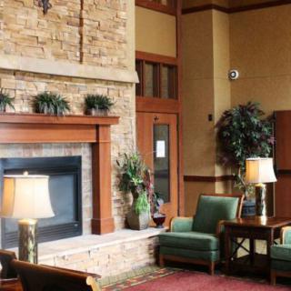 A cozy lobby area with a fireplace, comfortable seating, and warm lighting.
