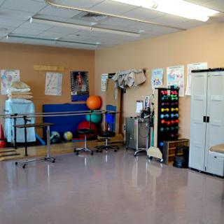 A well-equipped physical therapy room featuring various exercise tools and colorful equipment.