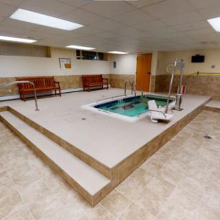 Indoor spa area with a small hot tub and seating for relaxation.