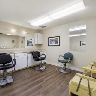 A well-lit salon interior with multiple styling chairs and mirrors.