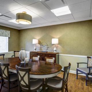 A cozy dining room with a round table and elegant decor.