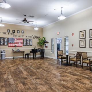 A spacious recreation room featuring a piano, seating area, and patriotic decor.