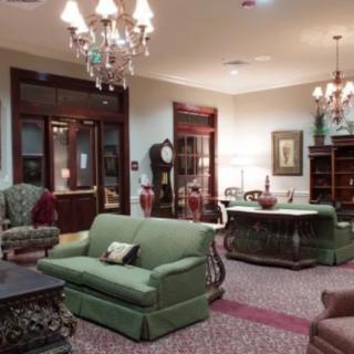 A cozy traditional living room with elegant furniture and a chandelier.