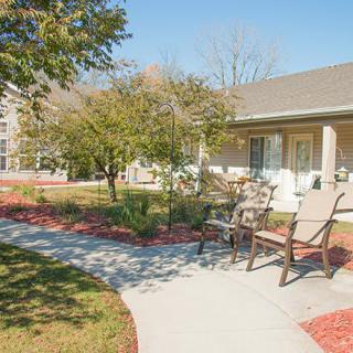 A serene garden with a bench and pathway under a clear blue sky.