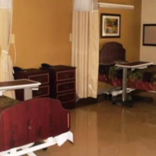 A hospital room with medical beds separated by curtains.