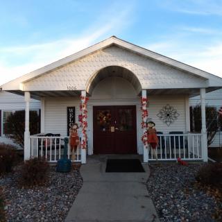 A house with a decorated entrance and porch, featuring autumn-themed decorations.