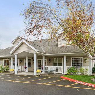 A residential building with a parking lot and autumn trees.