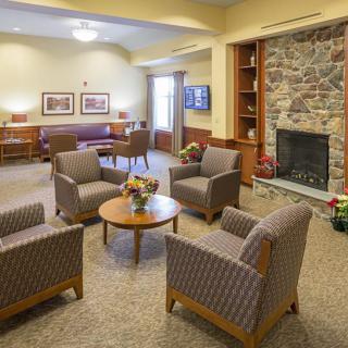 A cozy living room with a fireplace, comfortable seating, and warm decor.