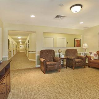 A cozy interior hallway featuring a seating area with comfortable chairs and soft lighting.
