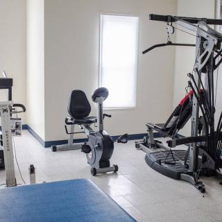 A clean, well-lit gym featuring various fitness equipment including an exercise bike and weight machine.