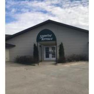 A commercial building with an entrance sign labeled 'Sportsman's Terrace'.